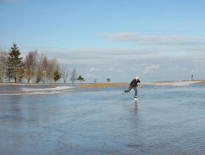 a man ice skating on a sheet of ice on a golf cours